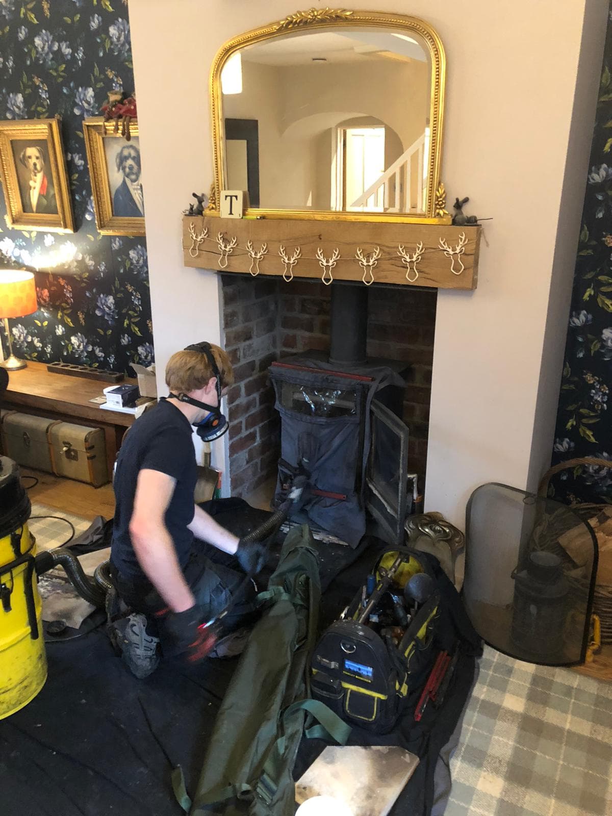 Sweeping a stove in a living room with dust sheets and vacuum in place